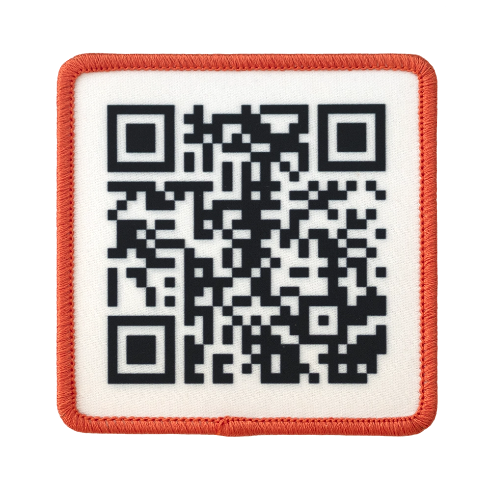 Painettu QR-koodi haalarimerkki, oranssit reunat, neliön muotoinen.
