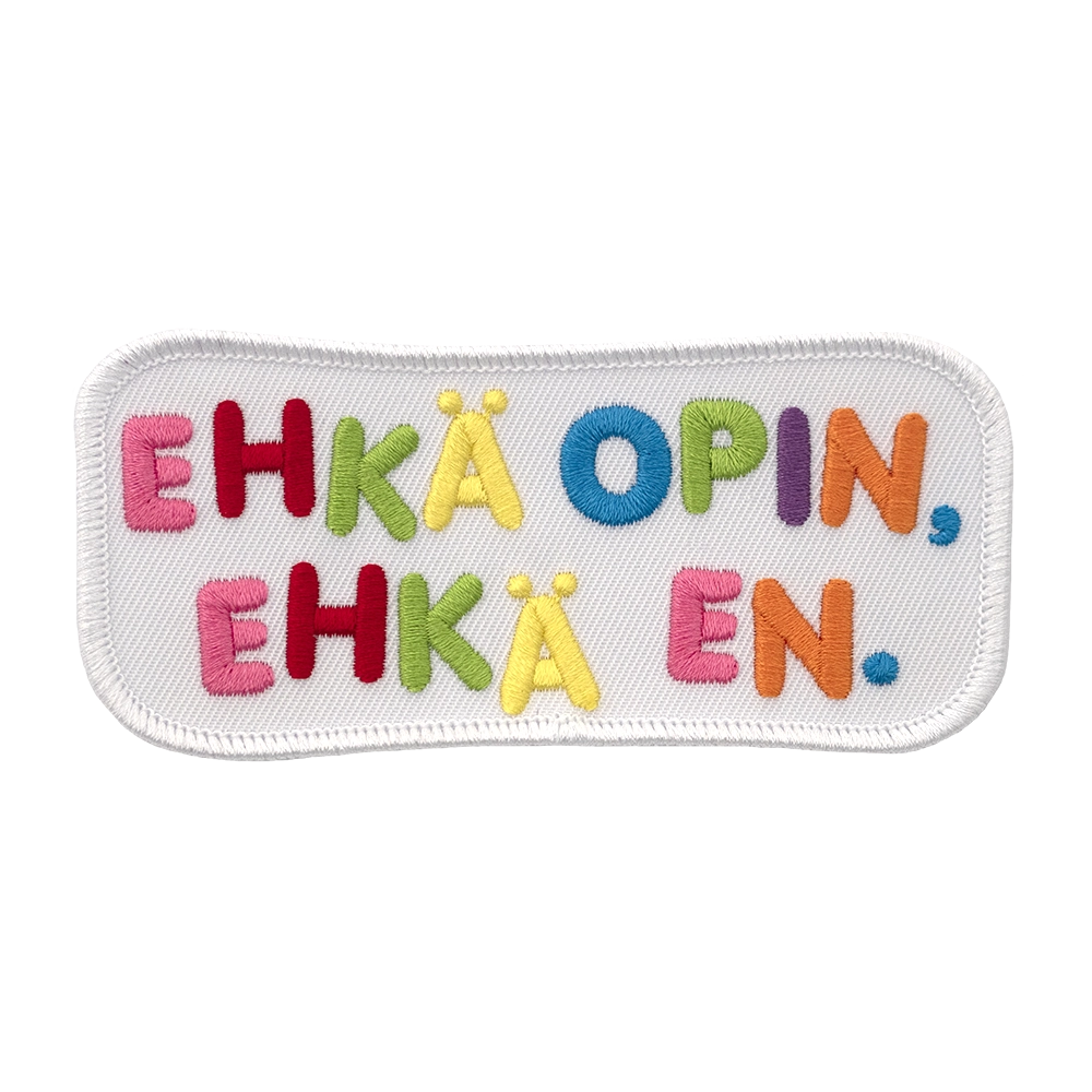 Brodeerattu haalarimerkki, valkoinen, värikäs teksti: Ehkä opin, ehkä en.
