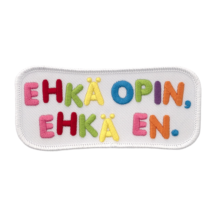 Brodeerattu haalarimerkki, valkoinen, värikäs teksti: Ehkä opin, ehkä en.