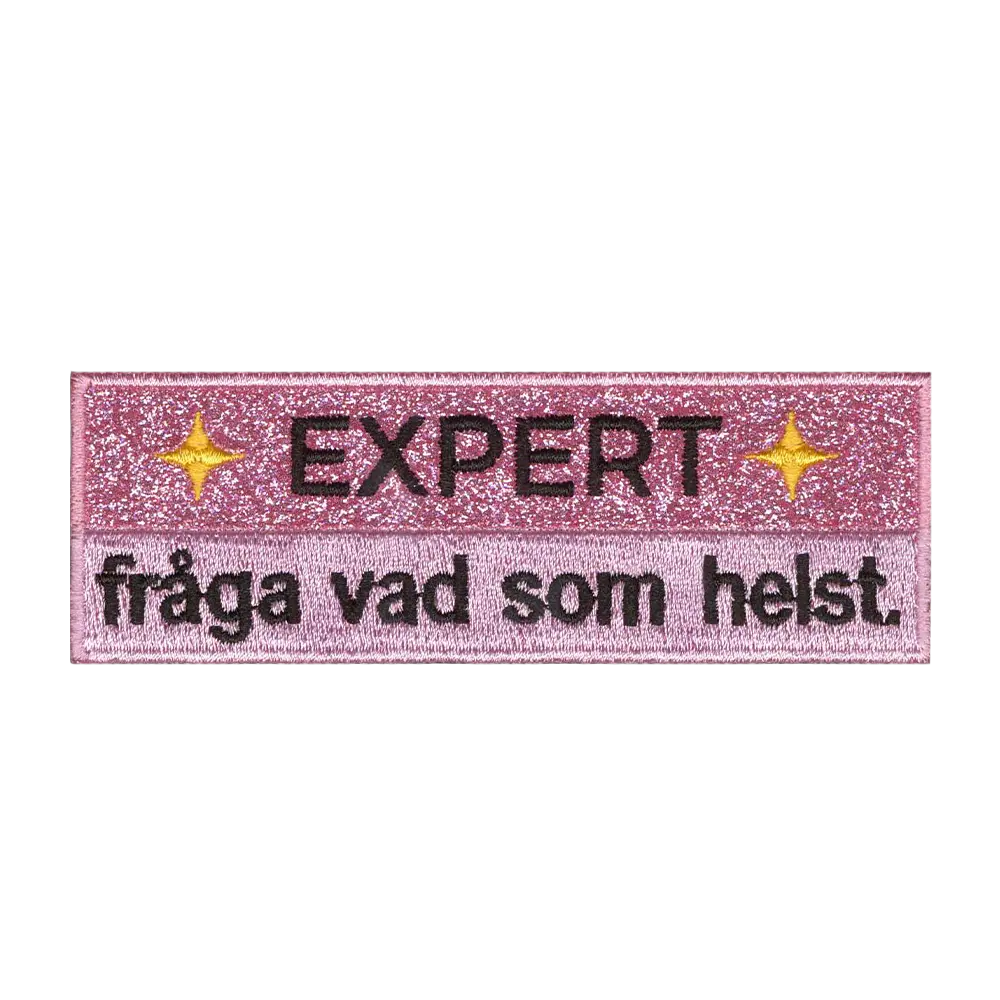Brodeerattu glitterkangasmerkki, teksti: Expert, fråga vad som helst.
