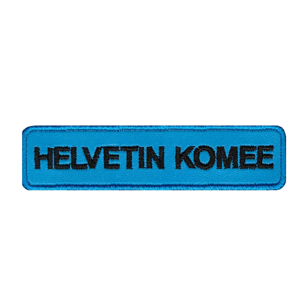 Nahkamerkki, sininen, teksti: helvetin komee.