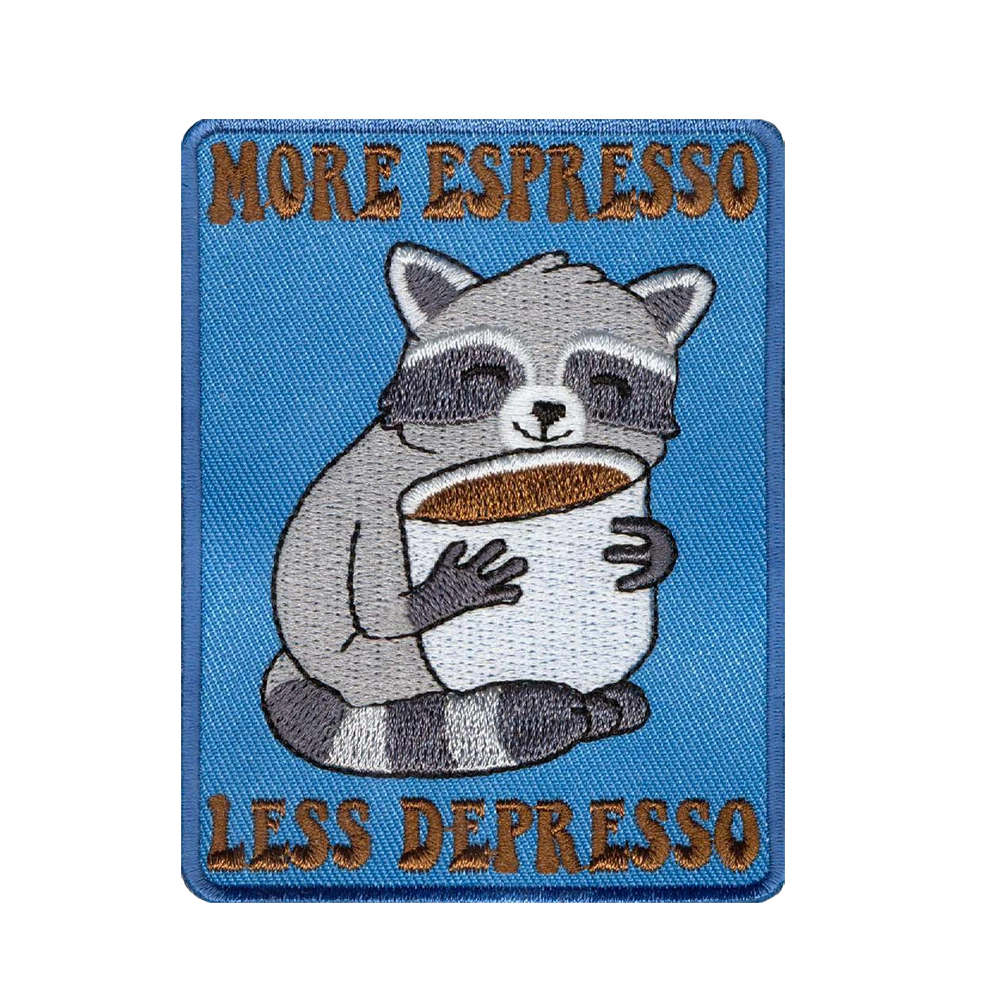 Brodeerattu haalarimerkki, pesukarhu, teksti: More espresso, less depresso.