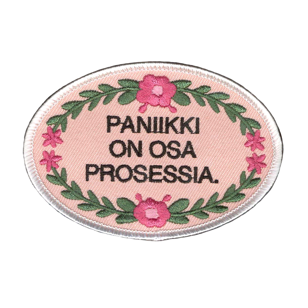 Brodeerattu kangasmerkki. teksti: Paniikki on osa prosessia.