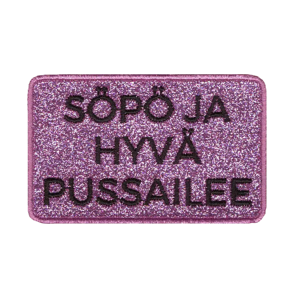 Brodeerattu kangasmerkki, teksti: Söpö ja hyvä pussailee.